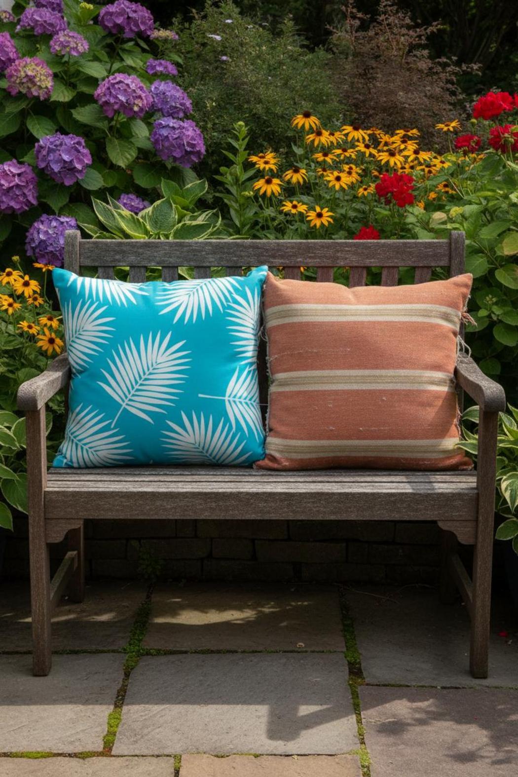 Faded standard cushion beside vibrant Sunbrella outdoor fabric patio cushion on stone garden bench in summer